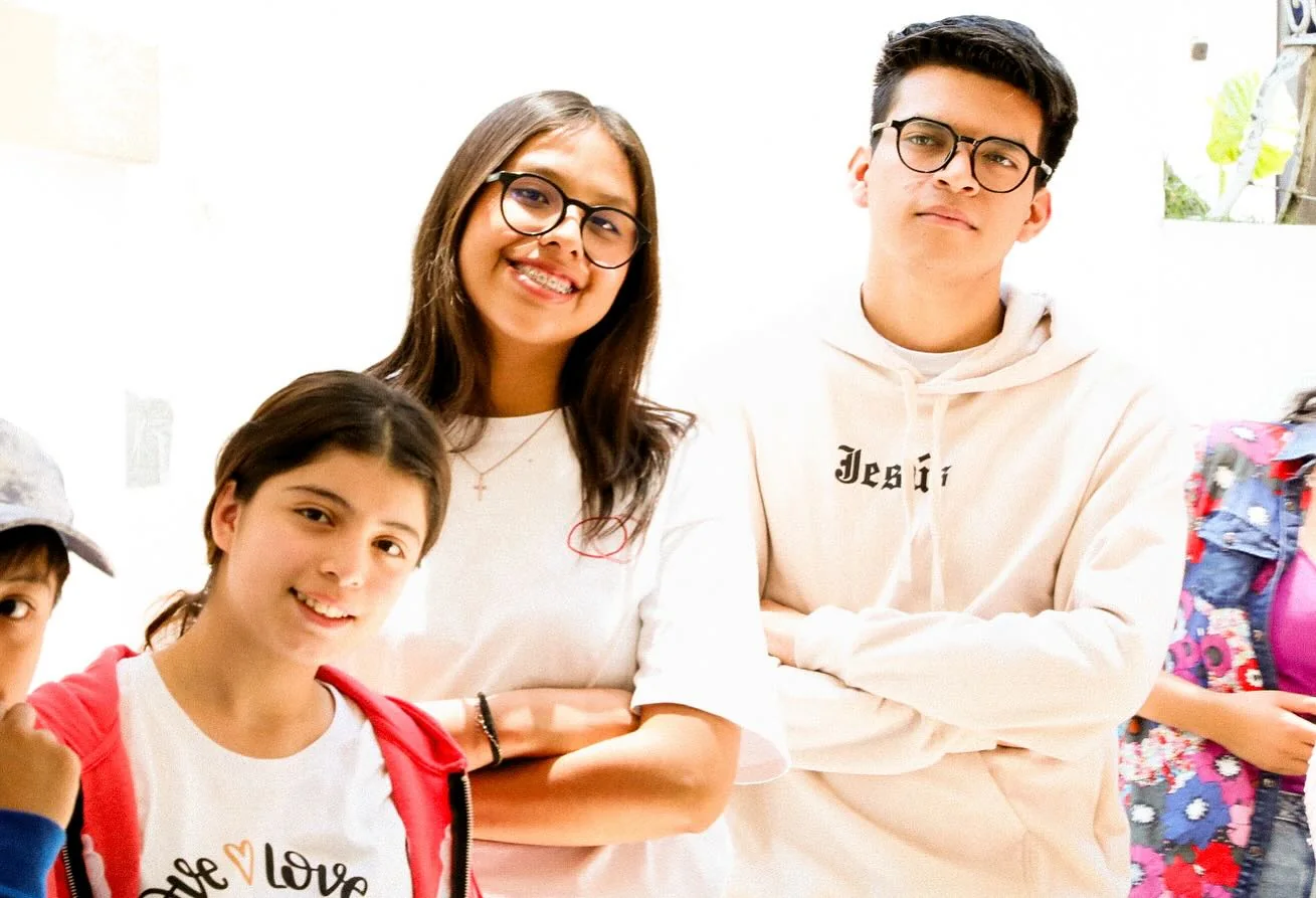 Tres jóvenes sonríen juntos