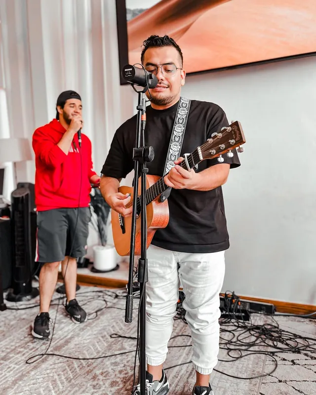 Músico toca la guitarra y canta en el equipo de alabanza