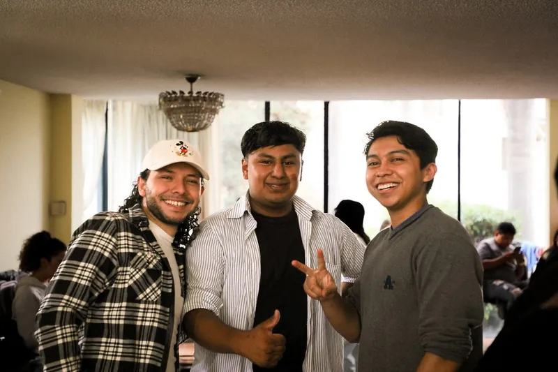 Tres jóvenes sonríen el primer día de REBORN 2024