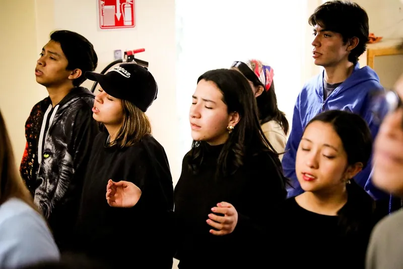 Jóvenes alaban con los ojos cerrados
