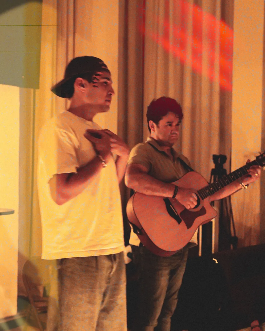 Dos jóvenes en alabanza, uno de ellos con guitarra, en la última noche de REBORN 2026