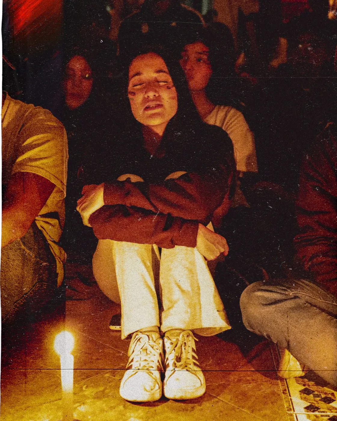 Joven en oración junto a una vela en la última noche de REBORN 2026