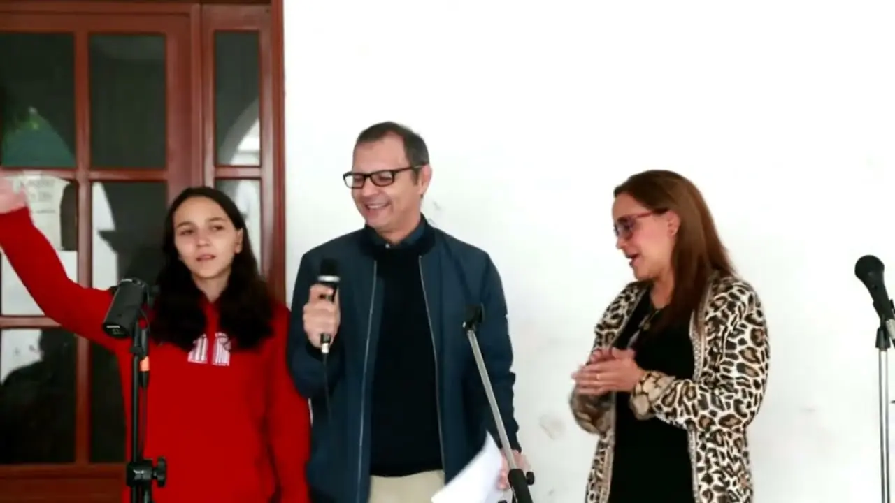 Una joven alza la mano en la alabanza del cierre de REBORN 2023.