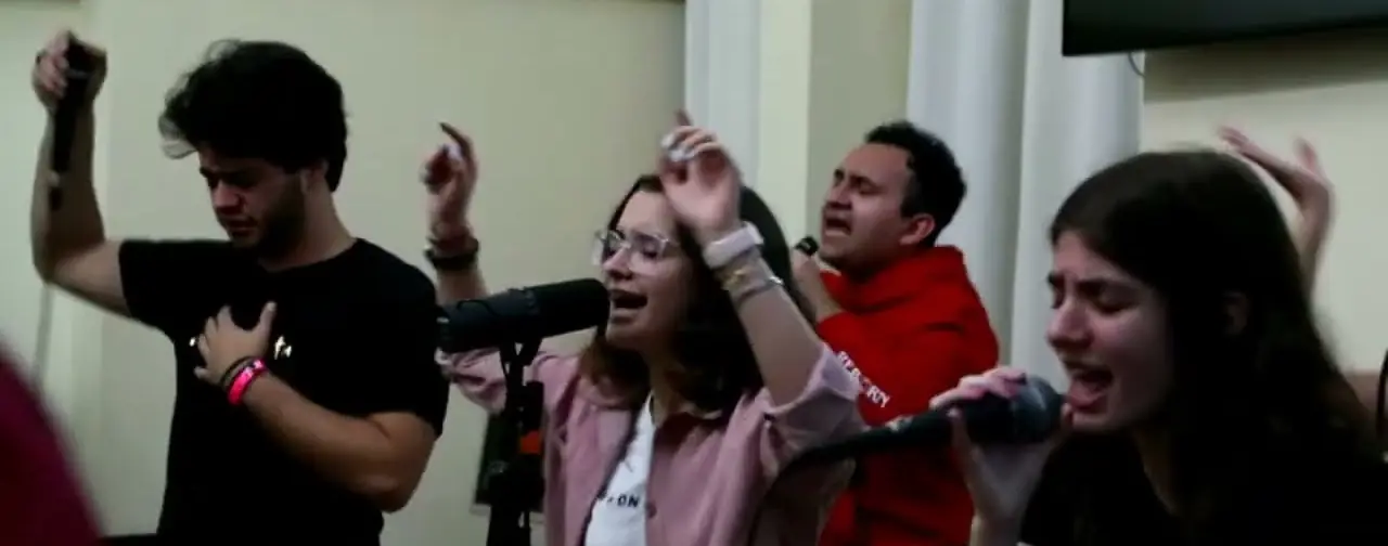 El equipo de alabanza canta con las manos en alto en la primera noche de REBORN 2023.