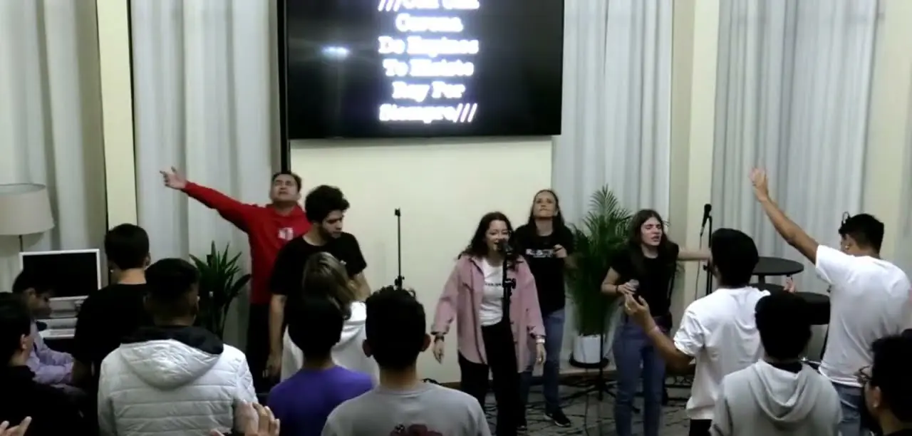 Jóvenes en la alabanza de la primera noche de REBORN 2023, con las manos alzadas.