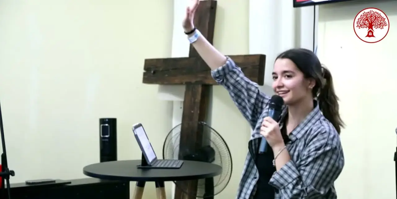 Una joven alza la mano mientras comparte con el micrófono en REBORN 2025.