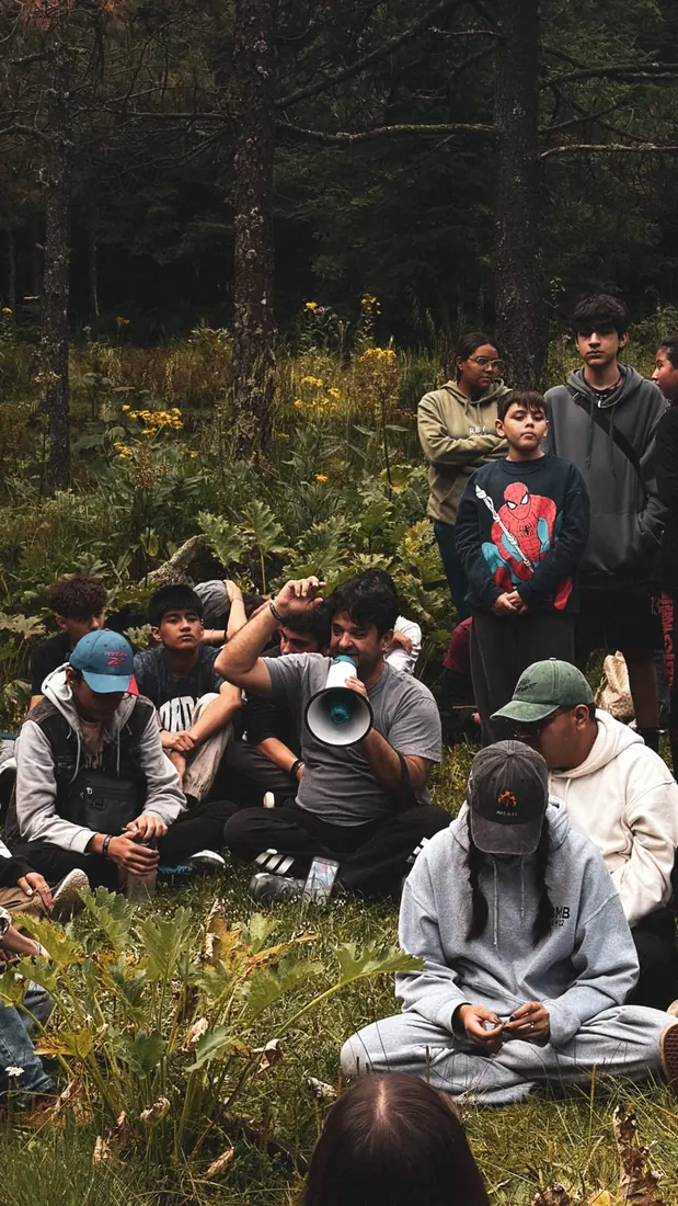 Jóvenes reunidos en el bosque para dar testimonio, durante la excursión de REBORN 2026.