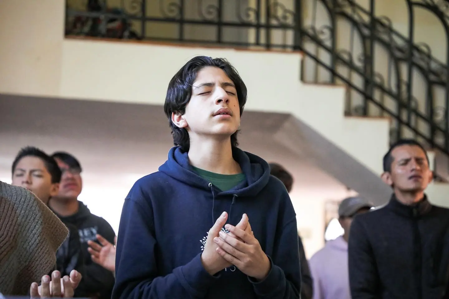 Un joven adora con los ojos cerrados durante la alabanza.