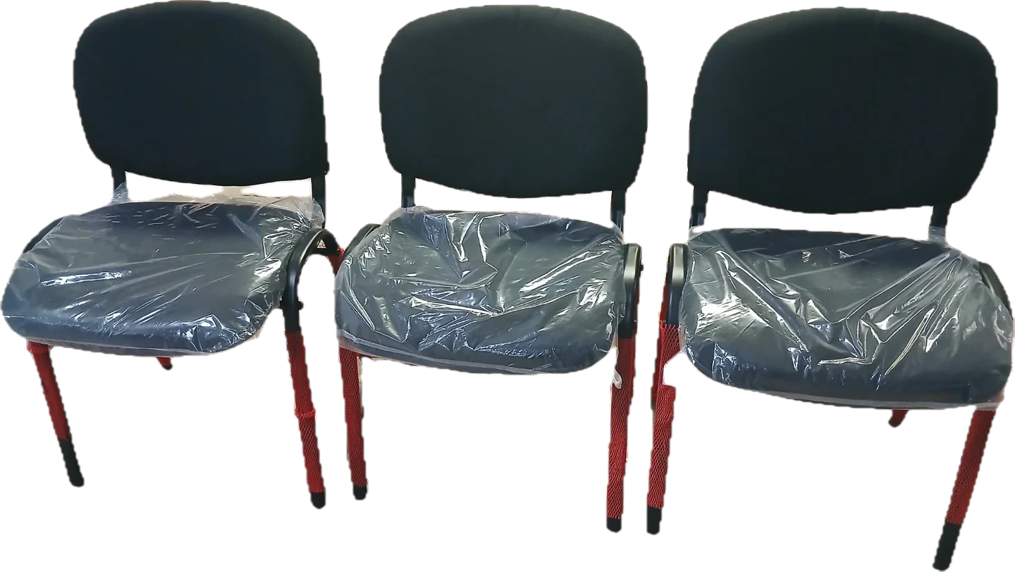 Tres sillas del modelo que se comprará: respaldo redondeado y asiento negros, patas rojas