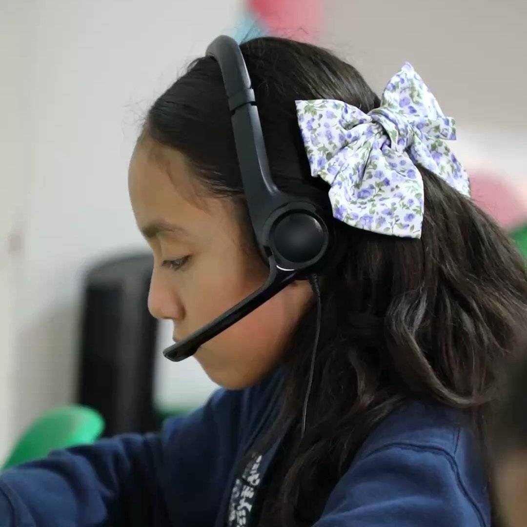 Una alumna de primaria del Instituto Zoe sigue su clase con diadema de audífonos y micrófono