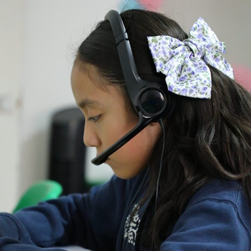 Una alumna de primaria del Instituto Zoe sigue su clase con sus audífonos