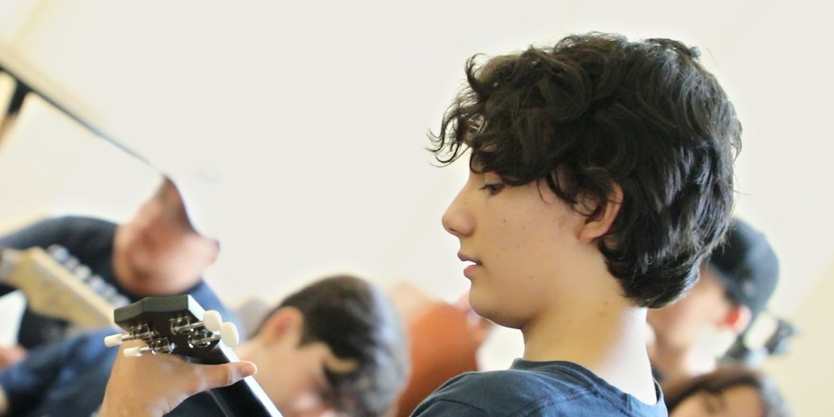 Clase de música en el Instituto Zoe: un alumno de secundaria toca su ukulele junto a sus compañeros