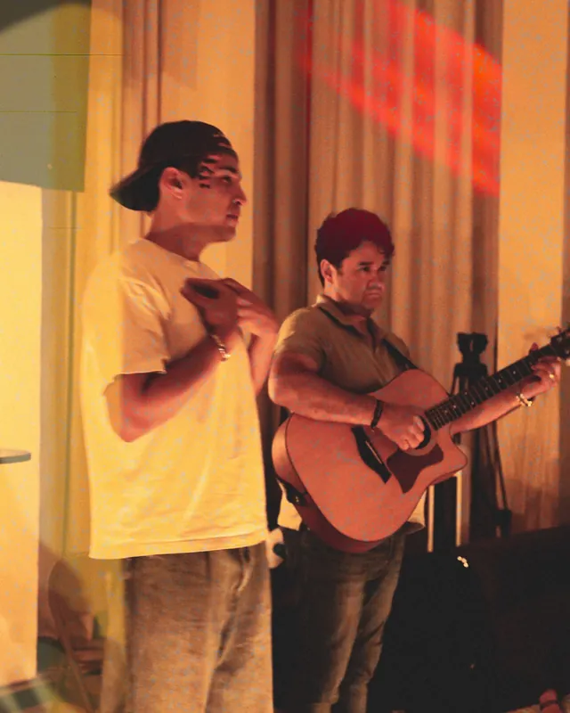 Dos jóvenes en alabanza, uno con guitarra